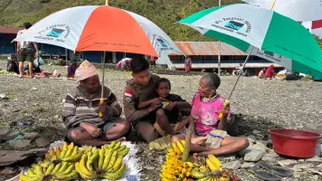 Senyum Mama-Mama Papua Saat Bripda. Rafly Personel Ops Damai Cartenz-2025 Ulurkan Payung